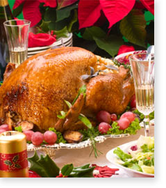 Holiday deep-fried turkey on beautifully decorated table of poinsettia and holly.